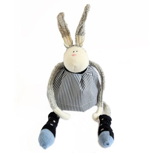 Stuffed sock animal bunny wearing a black and white striped shirt and socks