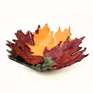 Bowl made of layered ceramic maple leaves in gold, red and green