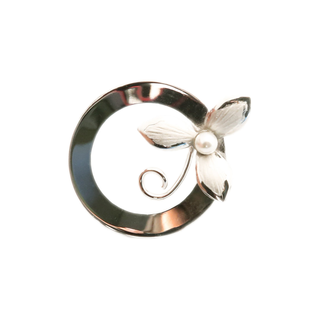 Round sterling silver brooch holding a trillium with a pearl at its centre