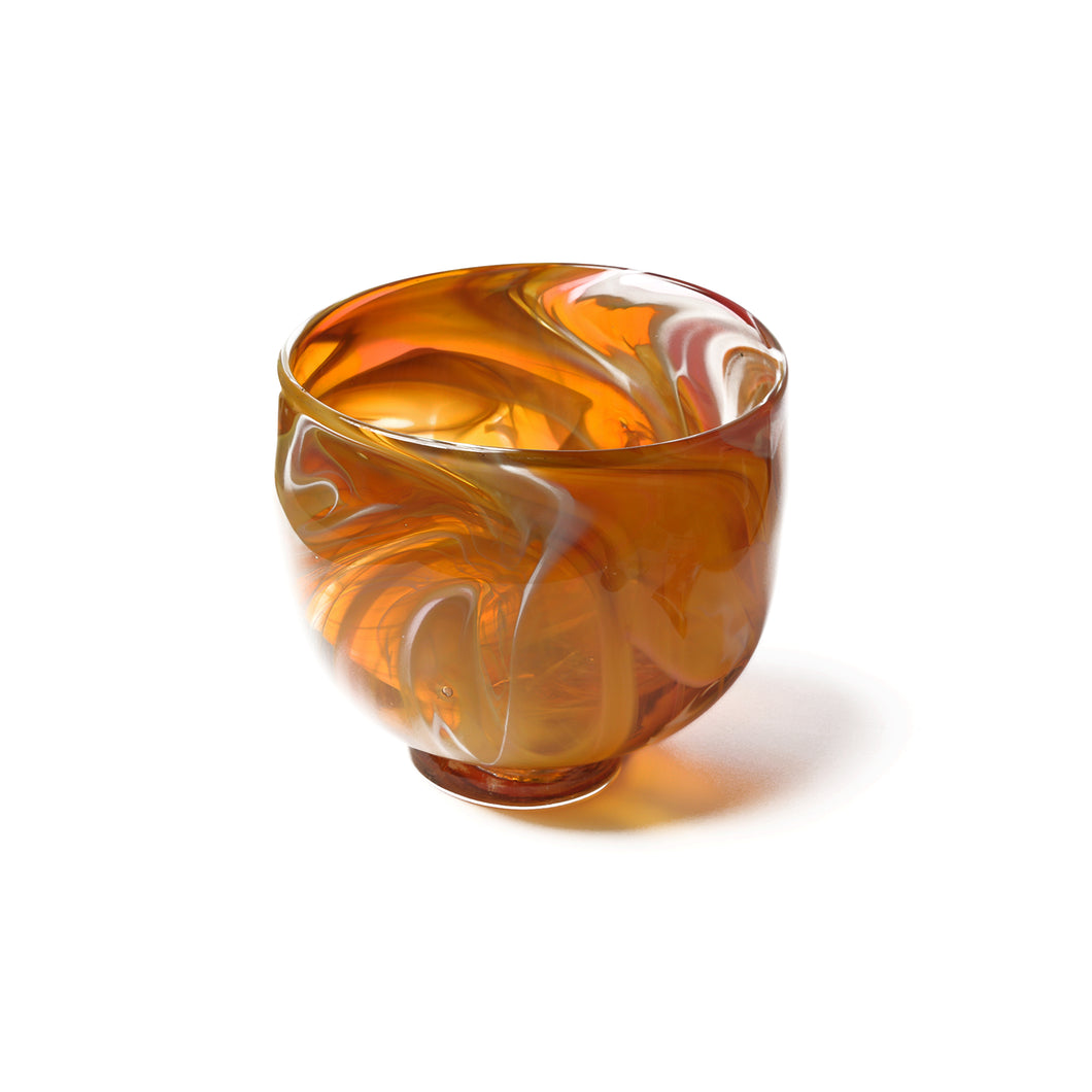 an amber glass bowl with swirls of white.